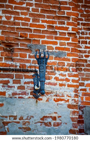 Metal torch stand on an old brick wall. Fragment of the Kolomna Kremlin. Kolomna, Russia.