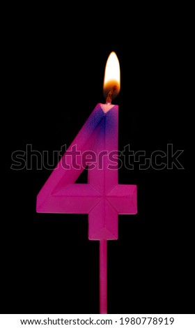 Pink birthday candle isolated on black background, number 4
