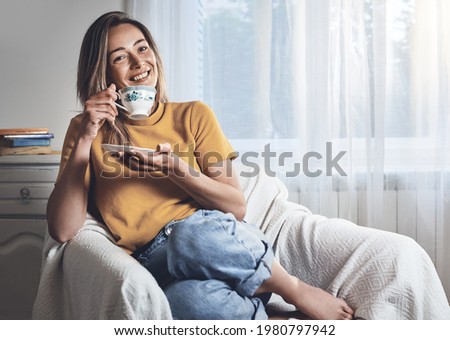 Woman relaxing with coffee at home. Young beautiful woman drinking coffee at home. Beautiful woman portrait