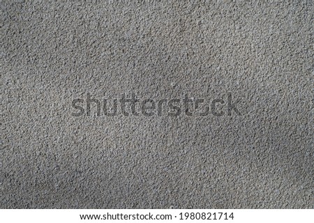 Photo of the wall surface. It is illuminated with partial shadows. Textured plaster based on a fine fraction of white color.