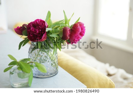 Bouquet of red peonies in a vase on the table