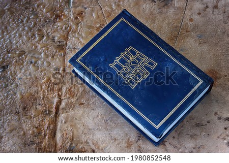 Hebrew Bible with raindrops on wet vintage background. Hebrew Bible is pronounced in Hebrew as an abbreviation of the Tanach from the words - Torah, Neviim, Ketuvim (title of the book, translation) Royalty-Free Stock Photo #1980852548