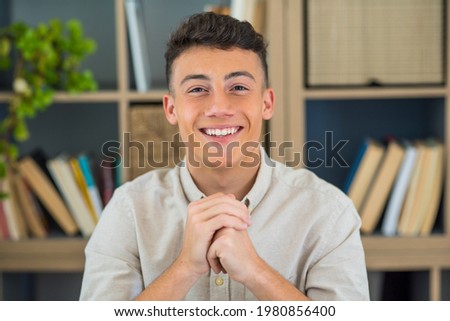 Portrait of one young and happy cheerful man smiling looking at the camera having fun. Headshot of male person working at home in the office. Royalty-Free Stock Photo #1980856400
