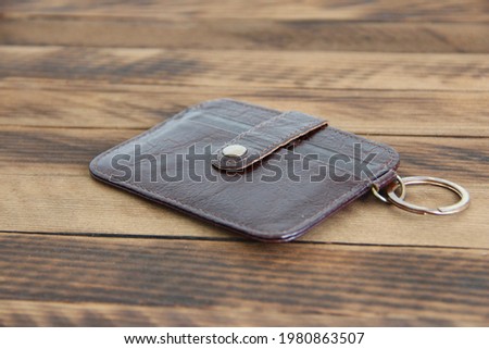 Leather wallet on the dark wooden background, close up