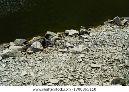 On the edge of a green river, bright white stones, wallpaper background, natural textures 