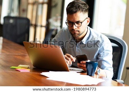 Businessman in office. Handsome man using the phone