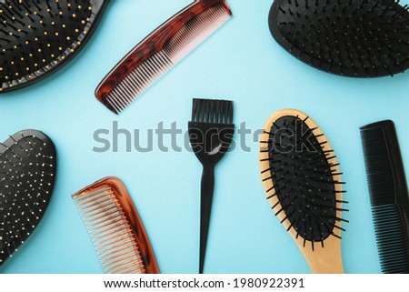 Hair tools, beauty and hairdressing concept - different brushes or combs on blue background. Top view