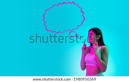Making a wish. Young beautiful girl dreaming isolated over blue background in neon light. Flyer. Concept of human emotions, facial expression, fashion, beauty, ad, sales, advertising. Collage
