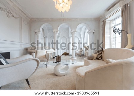 rich luxurious interior of a cozy room with modern stylish furniture nd grand piano, decorated with baroque columns and stucco on the walls Royalty-Free Stock Photo #1980965591