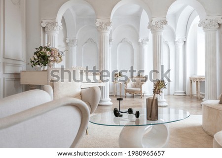 rich luxurious interior of a cozy room with modern stylish furniture nd grand piano, decorated with baroque columns and stucco on the walls Royalty-Free Stock Photo #1980965657