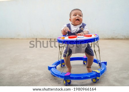 Cheerful Indian child in the baby walker.