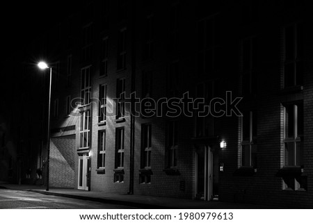 At night on the street,Apartment building is illuminated by street lamp, without people,black and white,Low Key Photography