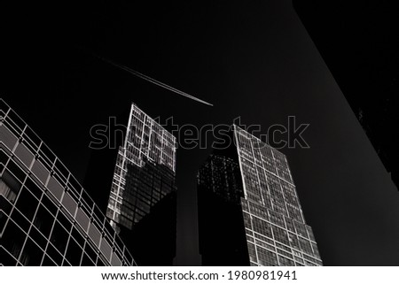 Urban black and white photo. Abstract modern architecture. Moscow city skyscrapers. Skyscrapers structure. Plane trace. Plane in the sky. Futuristic Moscow city financial district.