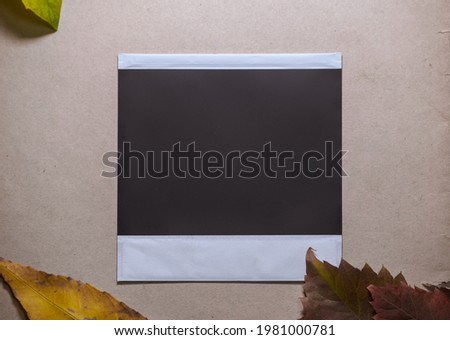 Blank photo frame with autumn leaves on brown background as template for graphic design. Photo card with space for your logo or text.