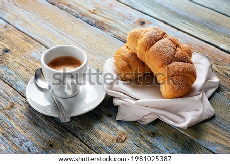 View from above. Cup of hot Italian espresso coffee and croissants on a light blue rustic wooden background. Food and drink. Lifestyle.
