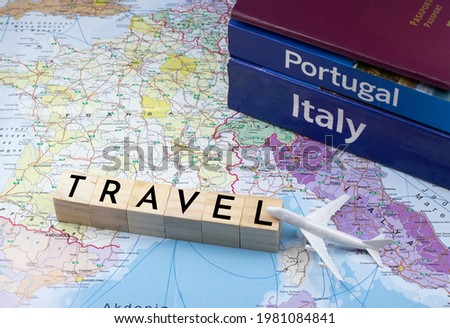 Travel concept, Travel message made from wooden cubes on world map with model airplane, passport and guide book, holiday planning idea