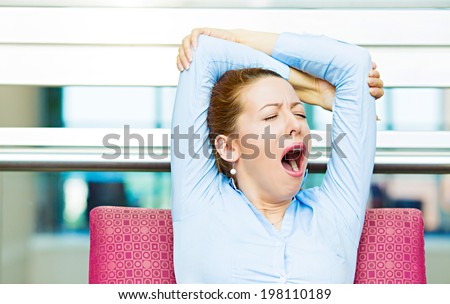 Its is too early for this meeting. Closeup portrait sleepy young business woman, sitting in armchair wide open mouth yawning, eyes closed, looking bored, isolated office windows background. Emotions Royalty-Free Stock Photo #198110189