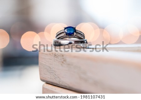 Bride's blue sapphire wedding ring with groom's wedding band. Macro view with bokeh