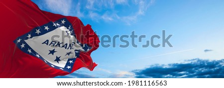 flag of Arkansas at cloudy sky background on sunset. Patriotic concept about state. 3d illustration