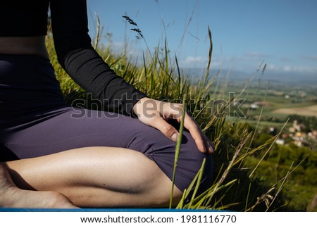 Close up picture of hands doing meditation.Young woman practices yoga in lotus position on an early sunny morning dew soft selective focus.