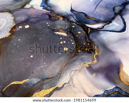 Abstract purple art with gold — violet and blue background with beautiful smudges and stains made with alcohol ink and golden pigment. Lilac fluid art texture resembles watercolor or aquarelle.