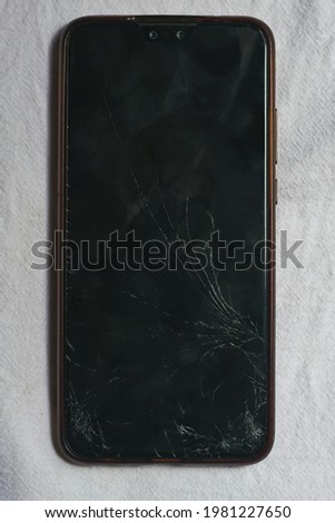 Mobile smartphone screen glass cracked on white cloth