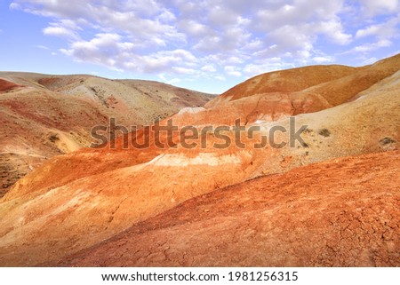 Mars in the Altai Mountains. The slope of the river terrace with the exposure of colorful clays and siltstones under the blue sky is a geological attraction. Chui Valley, Siberia, Russia