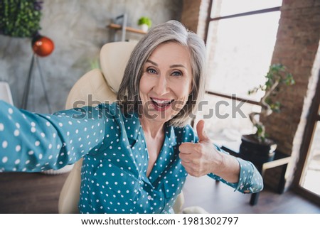 Photo of excited aged woman happy positive smile show thumb-up like cool advert advice make selfie home
