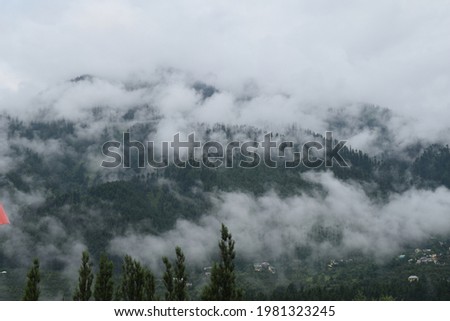 A picture of scenic beauty of Manali and its route to Rohtang pass, which has breathtaking view of Himalayan mountains and valleys covered with lush green forests and clouds and fog.