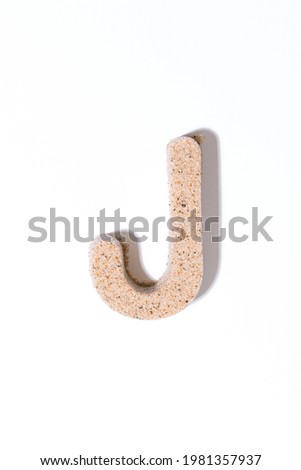 Letter J of the sand isolated in white. summer concept. alphabet.