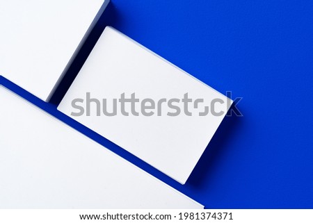 Blank white businesscards on classic blue background