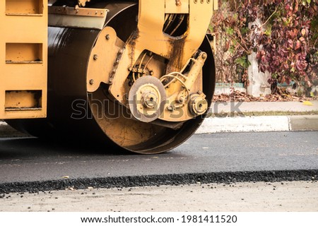 Laying of asphalt. Road roller tamping asphalt Royalty-Free Stock Photo #1981411520