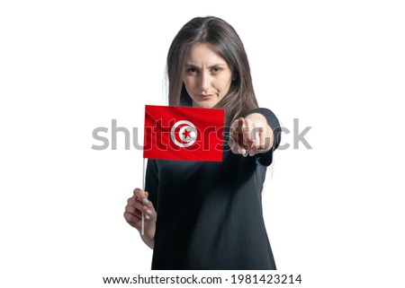 Happy young white woman holding flag of Tunisia and points forward in front of him isolated on a white background.