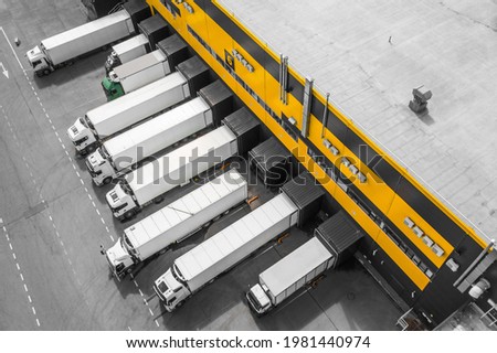 Aerial view of trucks loading in the distribution hub Royalty-Free Stock Photo #1981440974