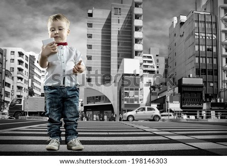 Child with phone stay on the crossroad