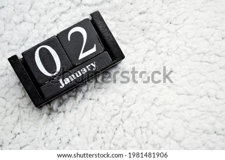 Wooden calendar from blocks on a white textile background with copy space. 2nd of January. Science fiction day