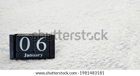 Wooden calendar from blocks on a white textile background with copy space. Banner. 6th of January. Christmas eve. Epiphany