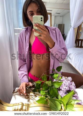 Fit tanned woman with perfect body, abs, tattoo on hip in bikini, take photo selfie on phone in mirror at home for social media, stories, vertical, summer concept