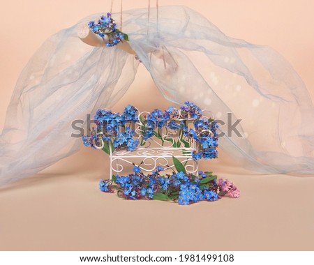 Vintage wicker crib on a yellow background, decorated with forget-me-not flowers