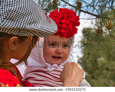 A young mother holding her beautiful baby girl on San Isidro day in Madrid