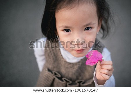 cute little kid having fun and playing outdoor, flower in hand