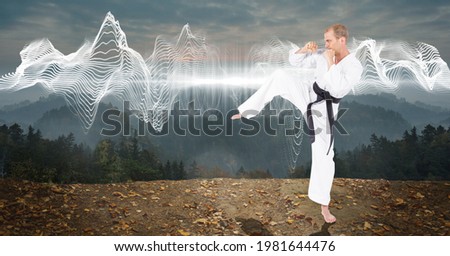 Composition of male martial karate artist with black belt practicing in mountains with copy space. sport and competition concept digitally generated image.