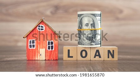 House model, money and Loan word on wooden cubes.