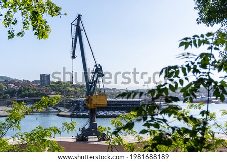 Crane of the port of Pasajes in the municipality of Lezo, the small coastal town in the province of Gipuzkoa, Basque Country. Spain Royalty-Free Stock Photo #1981688189