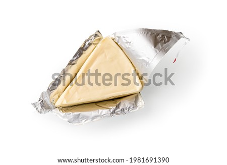 Foil wrapped processed creame cheese slice isolated on a white background. Small triangular piece of portioned soft cheese in a silver aluminium foil. Tasty sandwich ingredient. Macro. Top view. Royalty-Free Stock Photo #1981691390