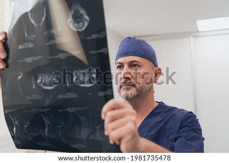 Orthopedist doctor examining X-ray picture in hospital or clinic 