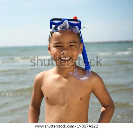 Close up portrait of a smiling little boy with snorkel by the sea