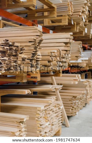 Warehouse with stacked wooden timber on racks for construction and repair Royalty-Free Stock Photo #1981747634