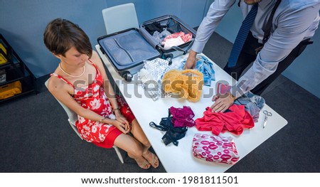 Police detective looking for drugs in luggage of the suspected girl Royalty-Free Stock Photo #1981811501