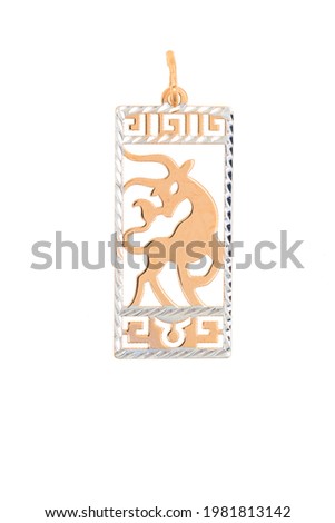 Golden zodiac sign Taurus pendant. The jewelry is isolated on a white background.